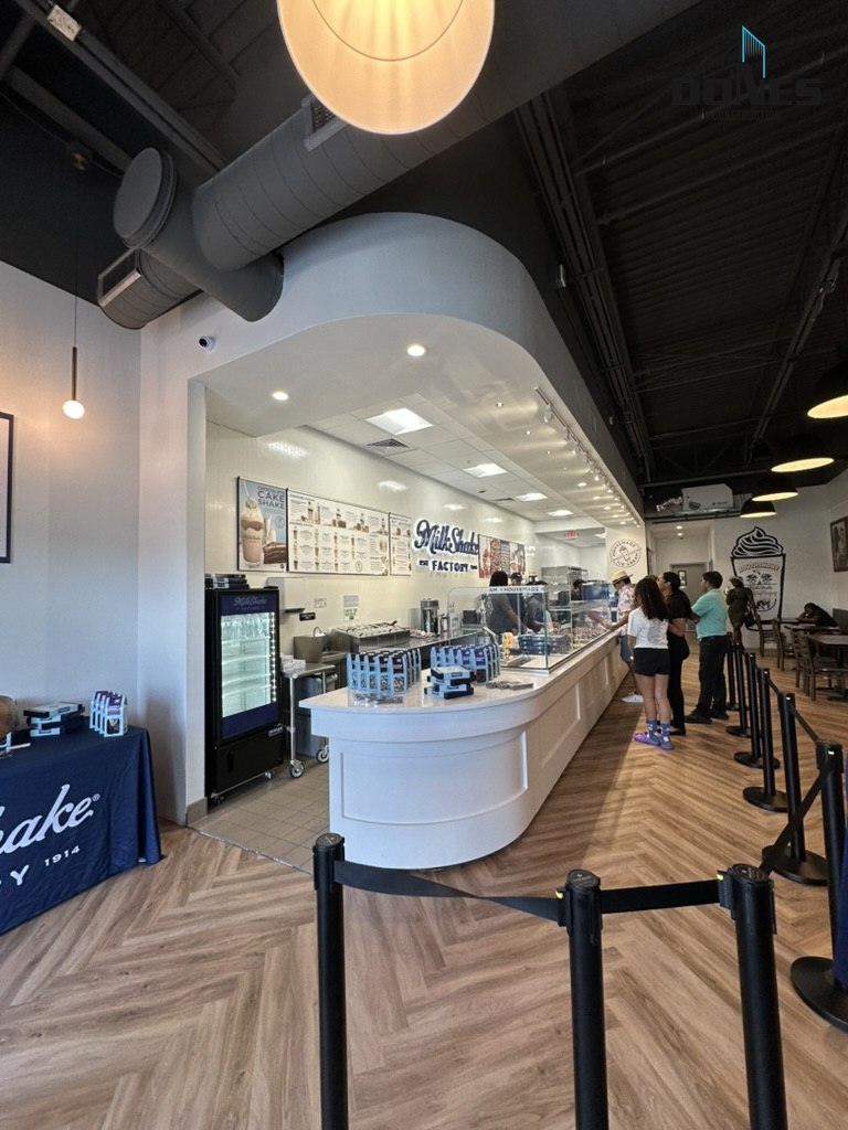 Milkshake Factory interior with a curved service counter, patterned flooring and customer queue
